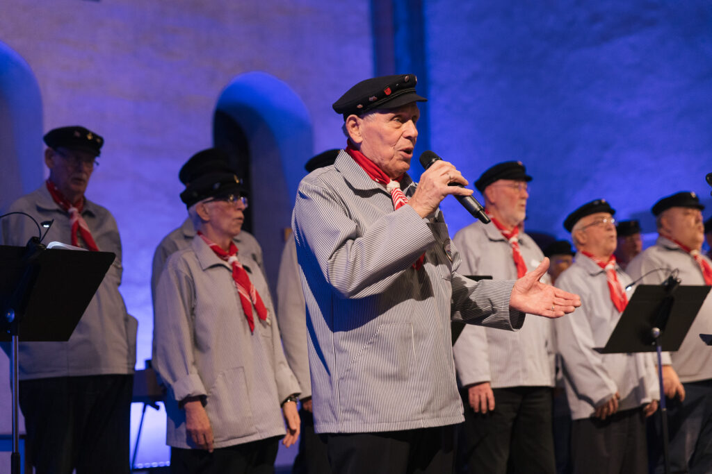 Ein Männerchor in Seemannskleidung singt im Altarraum der Kulturkirche St. Stephani