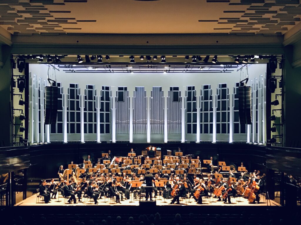 Blick auf die Bühne des Großen Saales der "Glocke". Im Hintergrund sind die Orgel und die großen Fenster zu sehen, auf der Bühne sitzt ein Orchester.