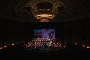 Blick in den Großen Saal des Stadttheaters Bremerhaven. Ein Orchester aus 200 Menschen musiziert gemeinsamen auf der Bühne.