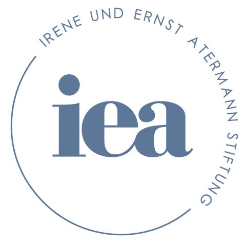 In blaugrauer Schrift auf weißem Grund sind die Buchstaben i e a zu sehen, in kreisförmiger Anordnung steht darum herum angeordnet: Irene und Ernst Atermann Stiftung